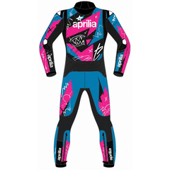 A full-body racing suit on a white background, featuring a vibrant graphic pattern of blue, pink, and black with the 'Aprilia' brand name and logo printed across the chest and down the sleeves and legs.