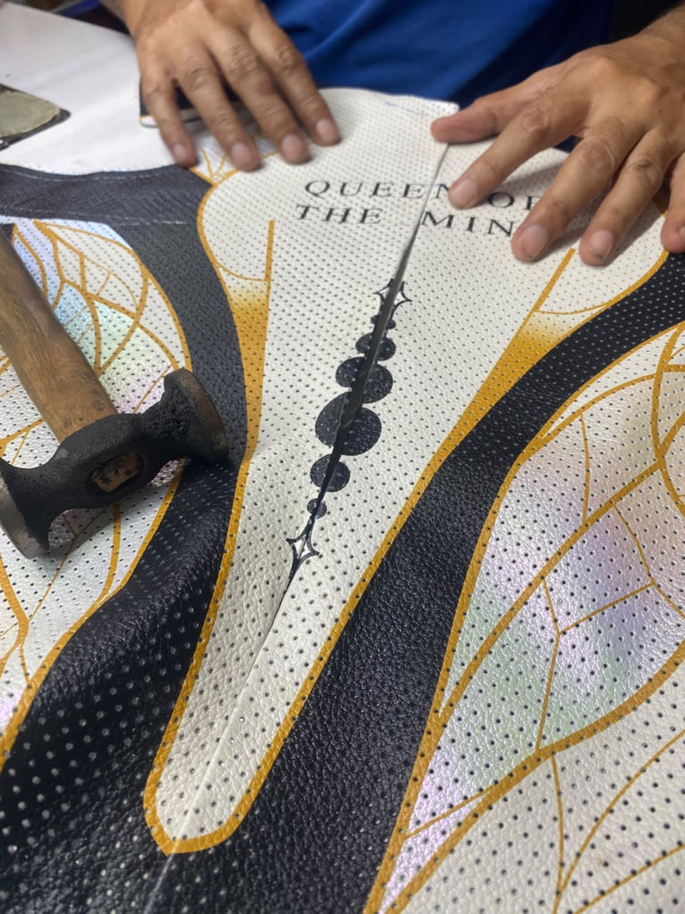 Craftsperson aligning personalized leather panels for a women’s made-to-order 1-piece motorcycle suit